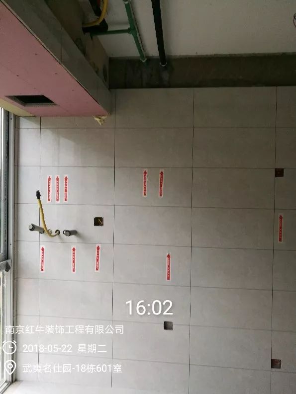 南京武夷名仕園124平米簡美風格裝修  享受家?guī)淼臏囟?0五月份_墻磚鋪貼完成后，紅牛裝飾的工人會用專用護角條對瓷磚角保護，用標貼標出水管、線管走向示意。